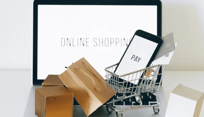 Online nakupování a mobilní platba s notebookem, nákupními taškami a kartou